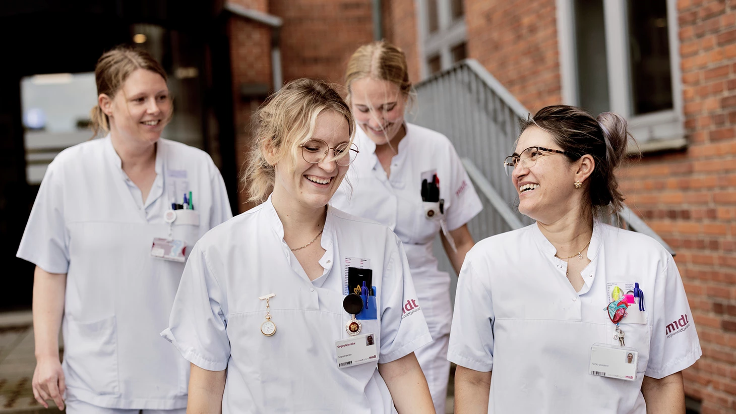 Medarbejdere i uniform på vej ned af trappe